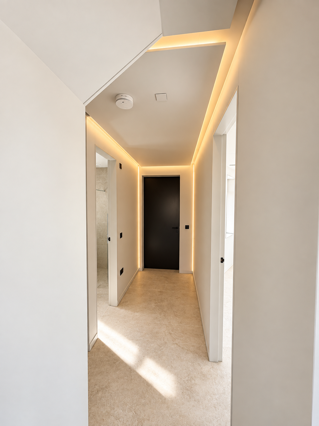 Hallway with stone floor and warm concealed lighting
