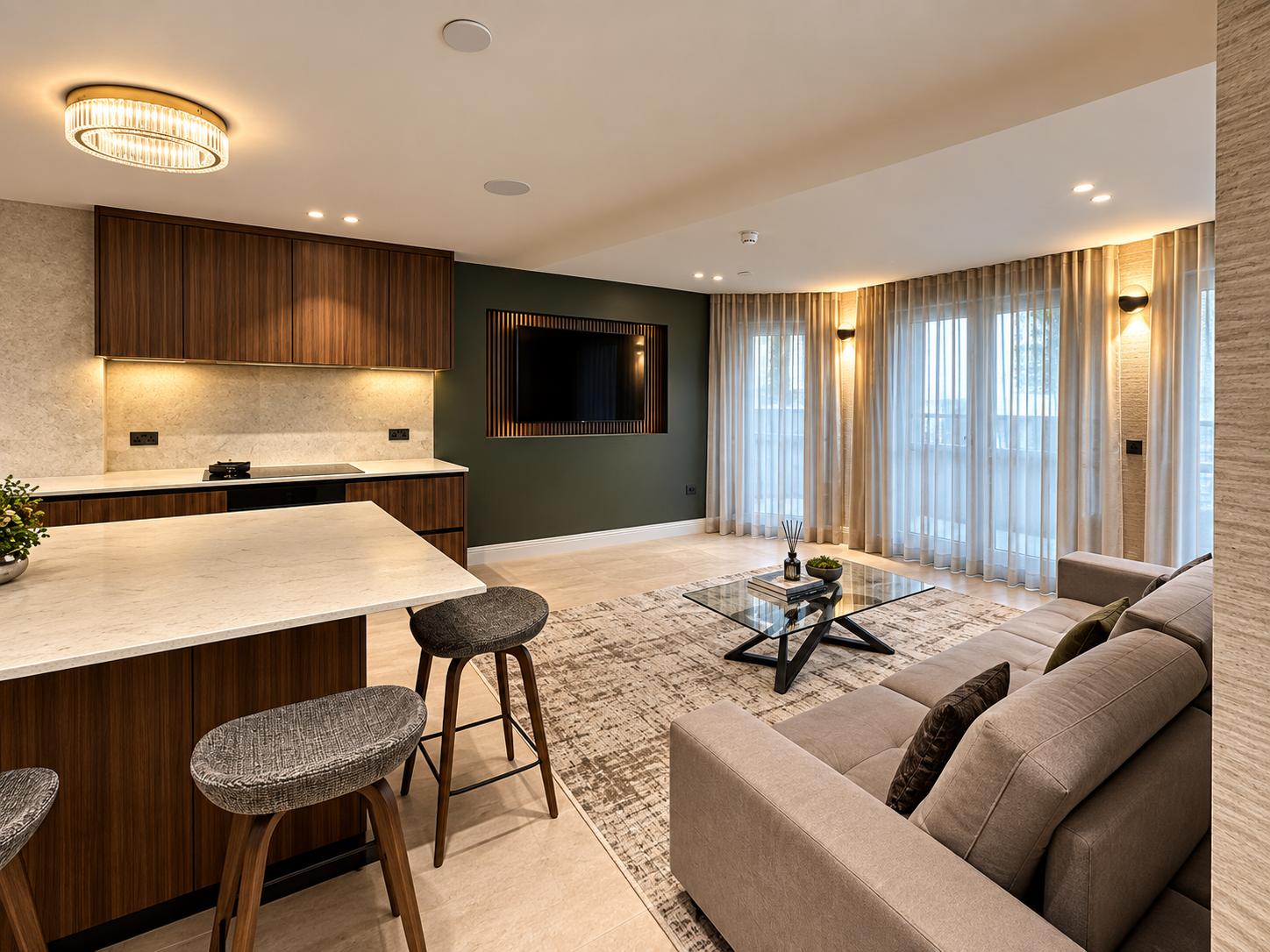 Walnut kitchen, grey sofa, green TV wall and full-height windows