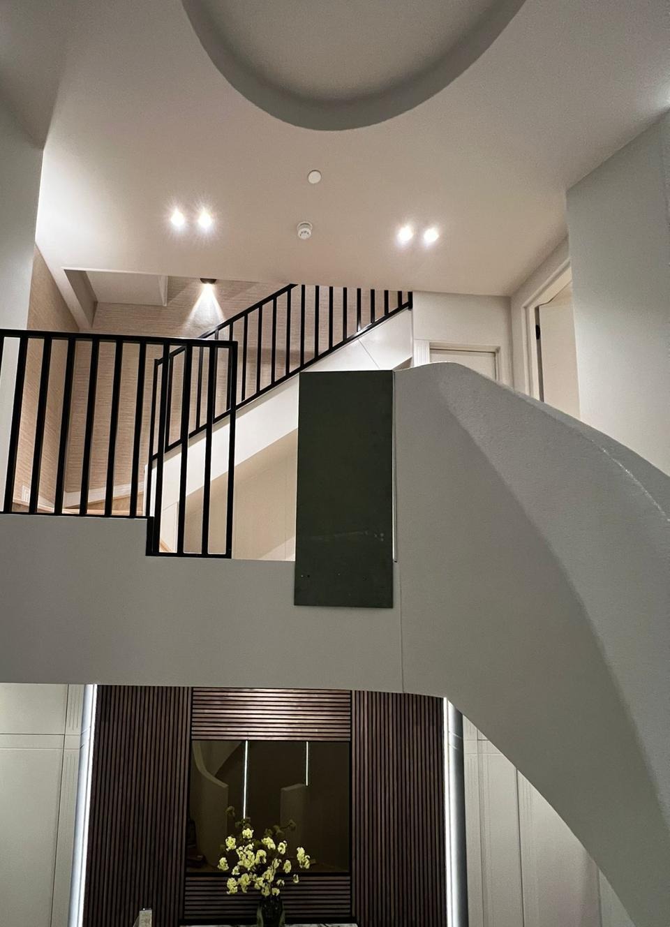 Staircase landing with black railings and marble console table