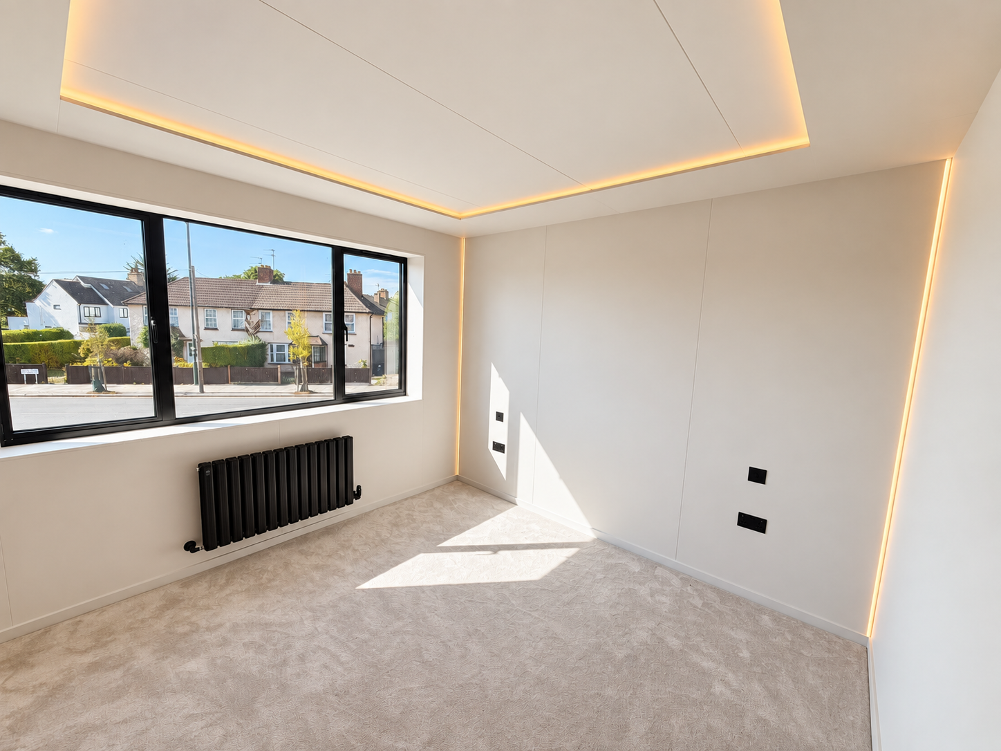 Second bedroom with lit ceiling coffer and wide window onto the street