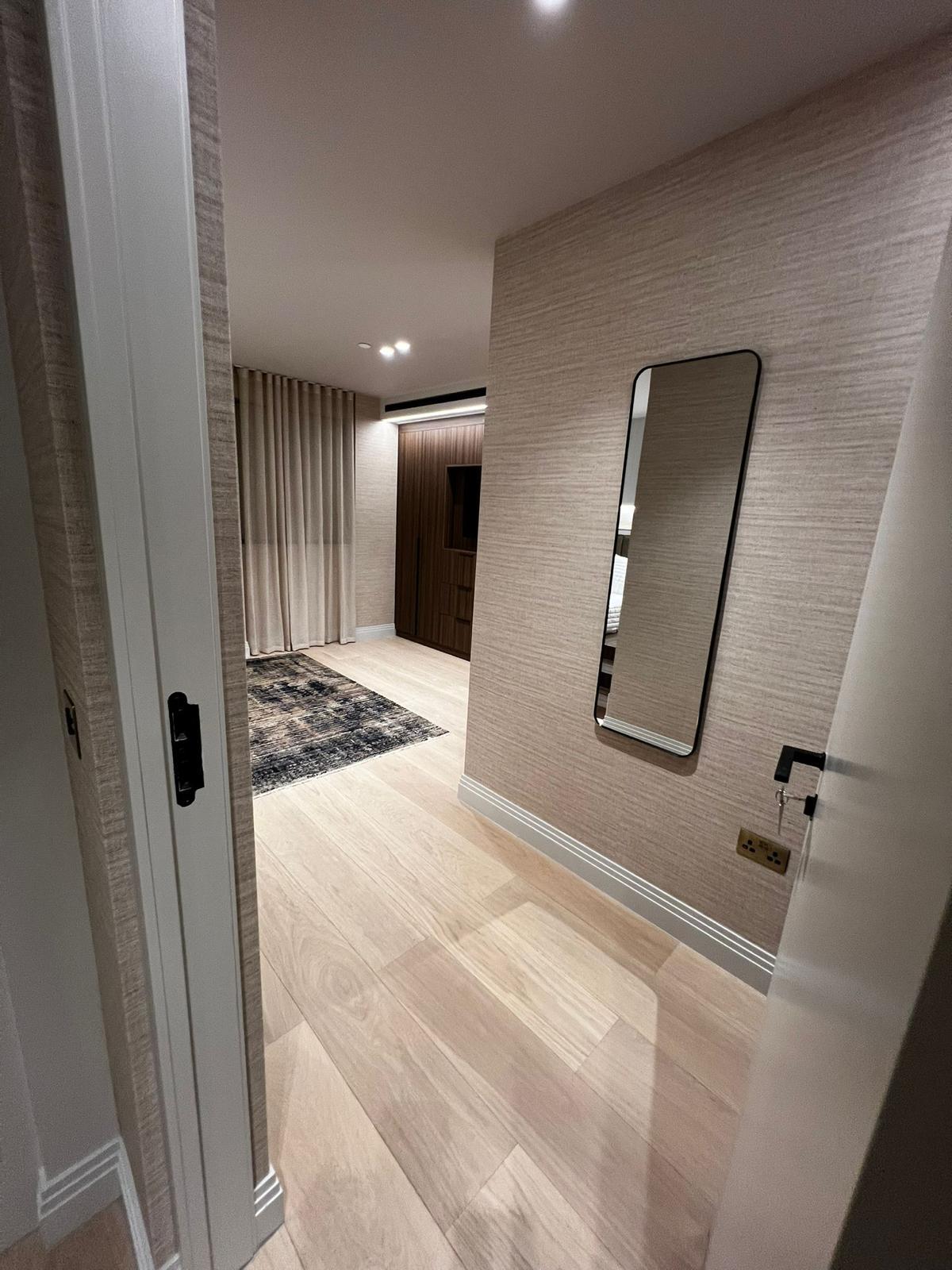 Curved hallway with warm fabric-lined walls and cove lighting